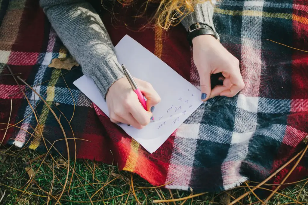 a person writing on a piece of paper