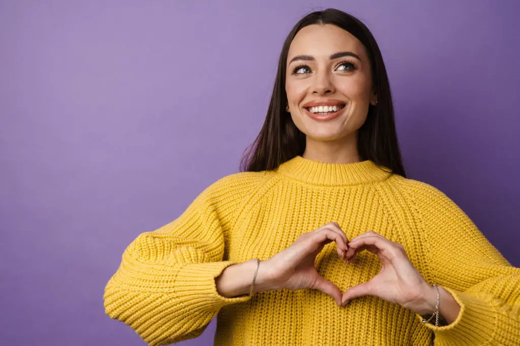 a girl holding her hands in a heart