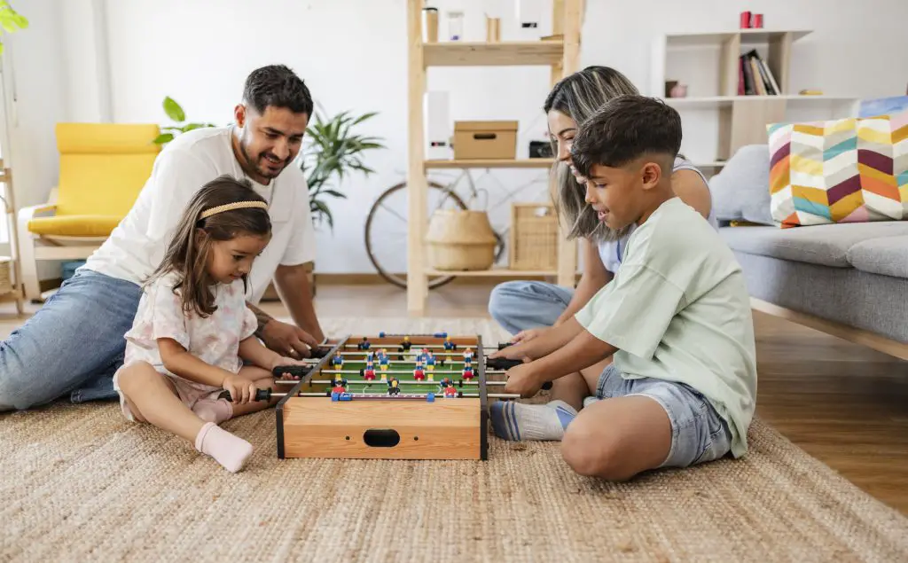 hispanic family playing foosball at home