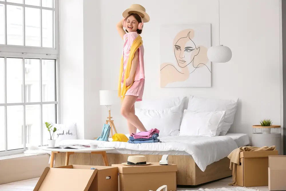 Young woman in headphones listening to music in bedroom