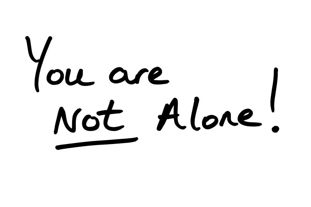 You are NOT Alone! handwritten on a white background.