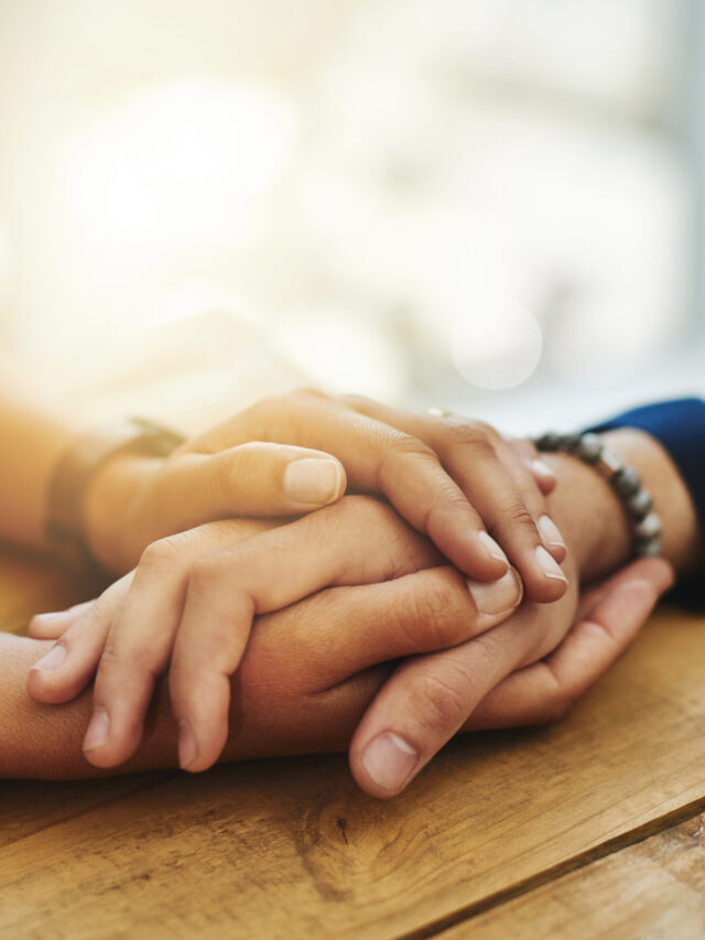 Holding hands showing care, love and support between friends, couple or family. People comforting, giving affection and embracing friendship with a hand gesture and touch during a difficult time